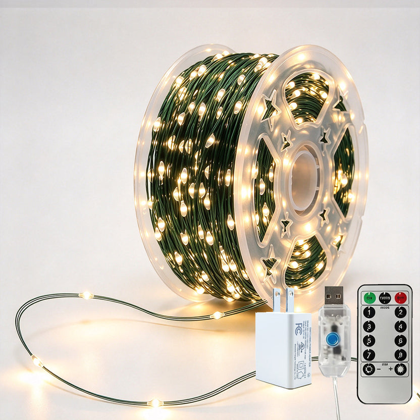 Green-wire copper fairy lights on a reel with warm-white LEDs, USB controller, remote and power adapter