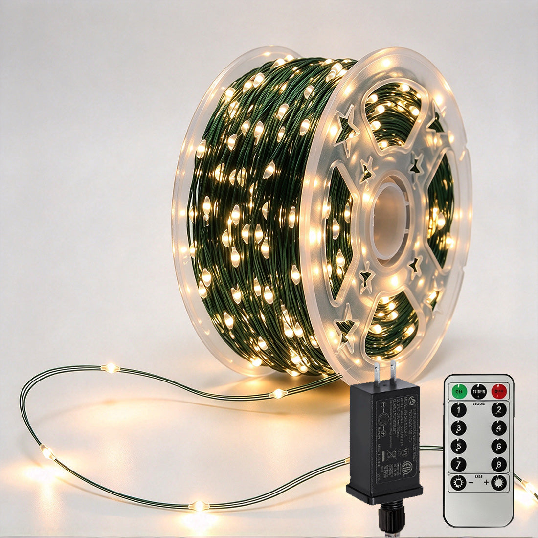 Green-wire copper fairy lights on a reel with warm-white LEDs, power adapter and remote