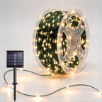 Green-wire copper fairy lights on a reel with warm-white LEDs and a solar panel
